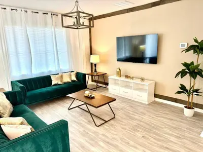a living room with a green couch and a flat screen tv at Disney Area Retreat 6BR4BA with Private Pool Theater Game Room Bella Vida Resort BV4509 in Kissimmee