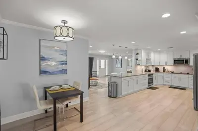 a large kitchen with white cabinets and a table at Luxury Ranch Master King Bed with heated Salted Pool in Orlando