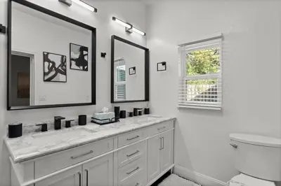 a white bathroom with a sink and a mirror at Luxury Ranch Master King Bed with heated Salted Pool in Orlando