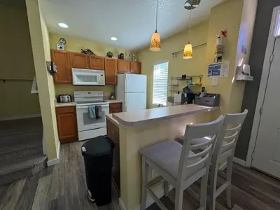 a kitchen with a counter and some chairs in it at 4 Bedroom 3 Bathroom Villas At SevenDwarfs 17-101 in Kissimmee