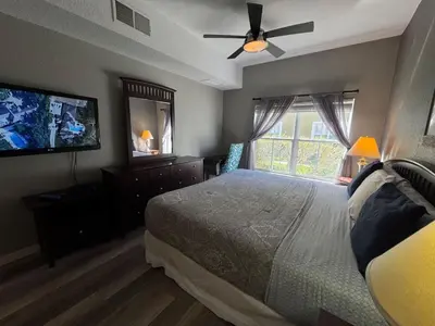 a bedroom with a bed and a flat screen tv at 4 Bedroom 3 Bathroom Villas At SevenDwarfs 17-101 in Kissimmee