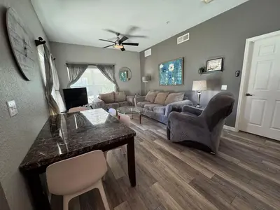 a living room with a table and a couch at 4 Bedroom 3 Bathroom Villas At SevenDwarfs 17-101 in Kissimmee