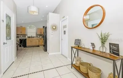 a kitchen with a table and a mirror on the wall at Enchanted Disney Vacation Villa in Kissimmee