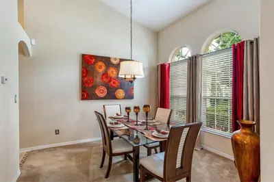 a dining room with a table and chairs and a painting at Beautiful 4 Bed Villa With Southwest Facing Pool in Orlando
