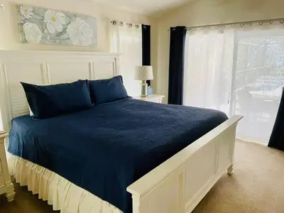 a bedroom with a bed with blue sheets and a window at Beautiful 4 Bed Villa With Southwest Facing Pool in Orlando