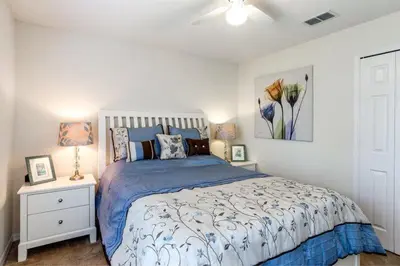 a bedroom with a bed with a blue comforter at Beautiful 4 Bed Villa With Southwest Facing Pool in Orlando