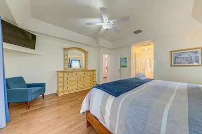 a bedroom with a bed and a blue chair at Spacious 4 Bed South Facing Pool Villa Near Disney in Orlando