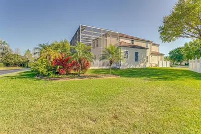 a house on a grassy field in front of a building at Spacious 7 Bedroom Home Close To Disney in Orlando