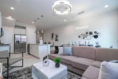 a living room with a couch and a kitchen at Luxury 3BR home with Mario Bros Room Near Disney in Orlando