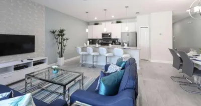 a living room with a blue couch and a kitchen at Perfect Storey Lake Home for Great Vacation in Kissimmee