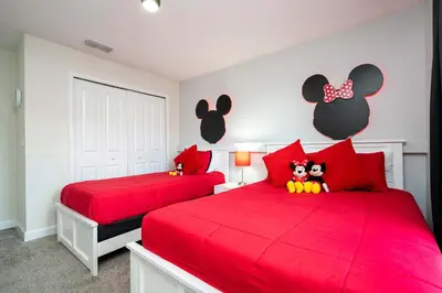a bedroom with two red beds with mickey mouse headboards at Storey Lake Home Mickey & Minions Beds Sleeps 12 in Kissimmee