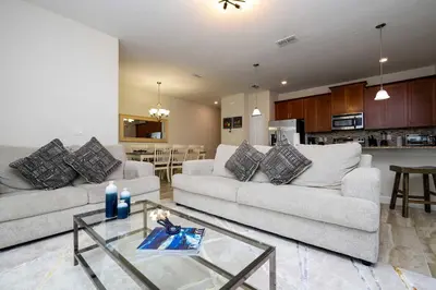 a living room with two white couches and a kitchen at Great Home Mickey & Harry Potter Beds Top Spot in Kissimmee
