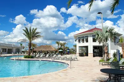 a resort swimming pool with chairs and a building at Elegant 2Bed Condo in Storey Lake Prime Location in Kissimmee
