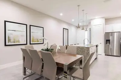 a kitchen and dining room with a wooden table and chairs at Chic 4 Bedroom at Summerville Minutes from Disney in Orlando