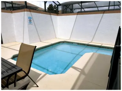 a small swimming pool with a chair and a table at Home 4Bed in Storey Lake with Private Pool in Kissimmee