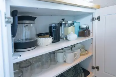 a cupboard filled with lots of cups and appliances at Historic orlando Casita Joy, DT, Lake Eola, Delaney park, 2 bedrooms 1 bathroom Unit B in Orlando