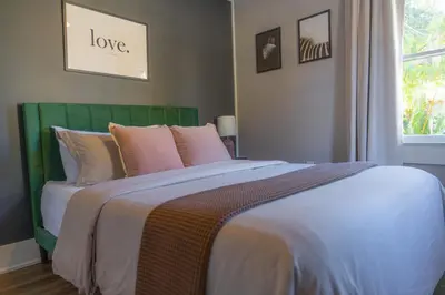a bedroom with a bed with a green headboard at Historic orlando Casita Joy, DT, Lake Eola, Delaney park, 2 bedrooms 1 bathroom Unit B in Orlando