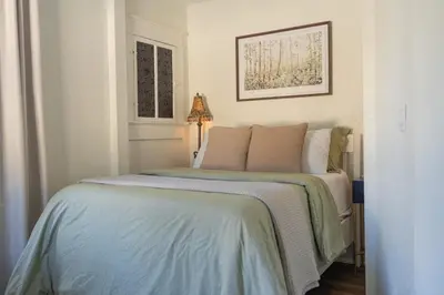 a bedroom with a bed with a green blanket at Historic orlando Casita Joy, DT, Lake Eola, Delaney park, 2 bedrooms 1 bathroom Unit B in Orlando