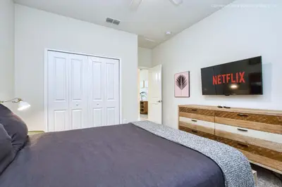 a bedroom with a bed and a tv on the wall at Chic Home Themed Bedrooms Game Room Best Spot in Kissimmee