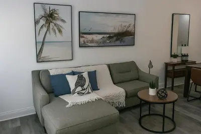a living room with a couch and a table at Disney-Area 3BR Townhome | Sleeps 9 | Pool + Gym in Kissimmee