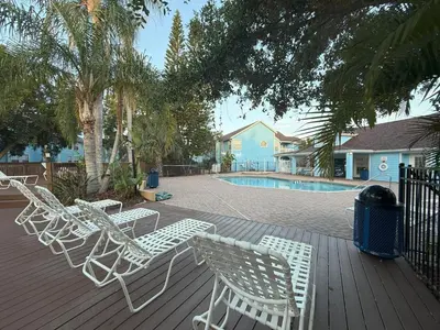 a deck with white chairs and a swimming pool at 2721 North Poinciana #164 in Kissimmee