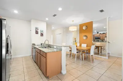 a kitchen and dining room with a table and chairs at 5 BD 4 BA Private Pool Paradise Palms (8839 CP) in Kissimmee