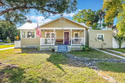 a yellow house with an american flag at Sanford's Haven, 3 Bedroom, Sleeps 7 in Sanford