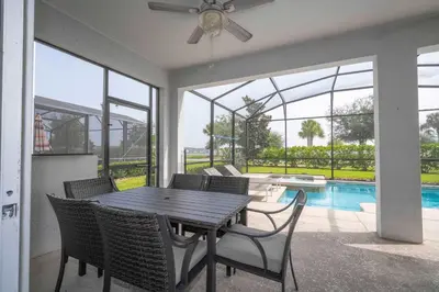 a dining room with a table and chairs and a pool at Home 6Bed , Themed Rooms, Game Room, Storey Lake in Kissimmee