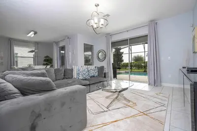 a living room with a couch and a table at Home 6Bed , Themed Rooms, Game Room, Storey Lake in Kissimmee