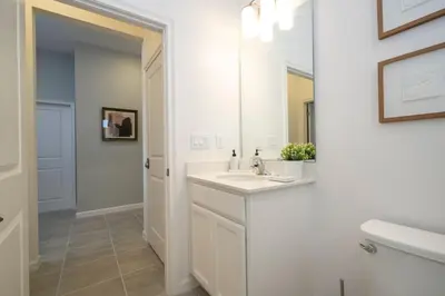 a white bathroom with a sink and a mirror at Relax at Paradiso Grande Resort in Orlando