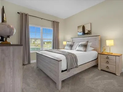 a bedroom with a large bed and a window at Comfortable 4 Bedrooms at Storey Lake in Kissimmee