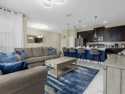 a living room and kitchen with a couch and a table at Comfortable 4 Bedrooms at Storey Lake in Kissimmee