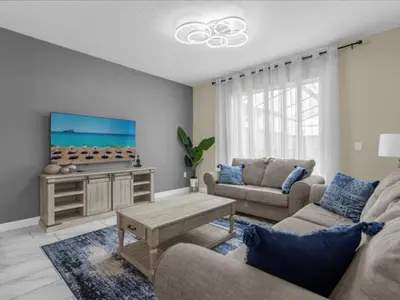 a living room with a couch and a tv at Comfortable 4 Bedrooms at Storey Lake in Kissimmee