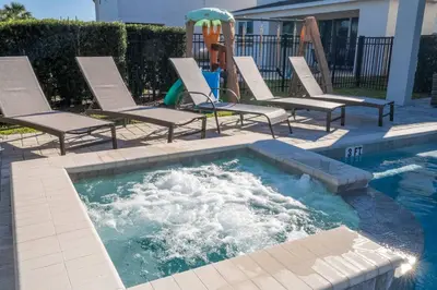a pool with lounge chairs and a water slide at Fantastic Disney Vacation W Pool and Movie Theater in Orlando