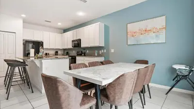 a kitchen with a white table and chairs at Summer Sale - Beautiful 6BR Home with Private Pool! in Kissimmee