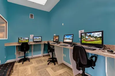 an office with four computer desks with computers on them at Summer Sale - Beautiful 6BR Home with Private Pool! in Kissimmee