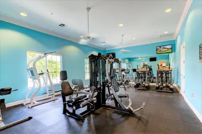 a gym with several tread machines in a room at Summer Sale - Beautiful 6BR Home with Private Pool! in Kissimmee