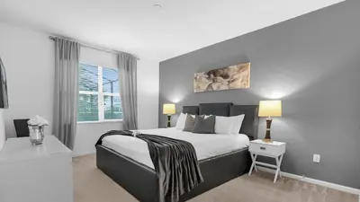 a bedroom with a large bed and a window at Summer Getaway in FL - 6BR Home with Private Pool! in Kissimmee