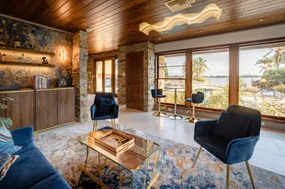 a living room with a blue couch and chairs at Luxury Lakefront 100,000 Gal Pool Villa - Orlando in Orlando