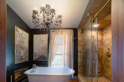a bathroom with a large tub and a chandelier at Luxury Lakefront 100,000 Gal Pool Villa - Orlando in Orlando