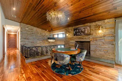 a living room with a table and a stone wall at Luxury Lakefront 100,000 Gal Pool Villa - Orlando in Orlando