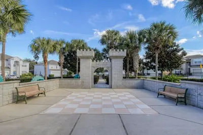 two benches in a courtyard with palm trees at Personally Designed Home w/ Pool, Game Room near Disney in Orlando