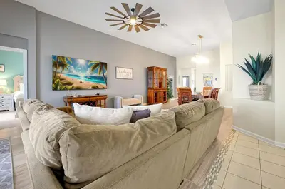 a living room with a couch and a dining room at Personally Designed Home w/ Pool, Game Room near Disney in Orlando