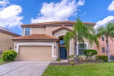 a house with a garage and palm trees at 2614 Veranda Palms in Kissimmee