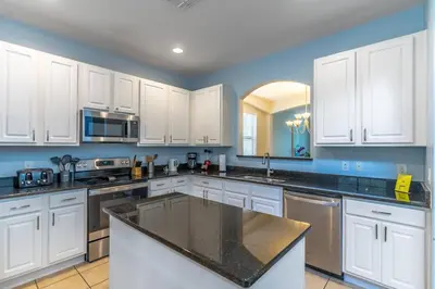 a kitchen with white cabinets and a black counter top at 2614 Veranda Palms in Kissimmee