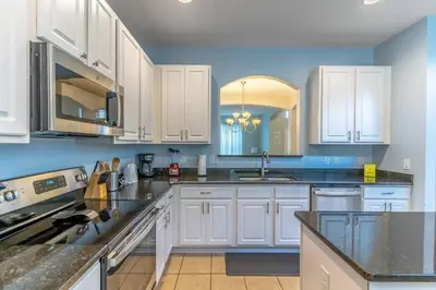 a kitchen with white cabinets and black counter tops at 2614 Veranda Palms in Kissimmee