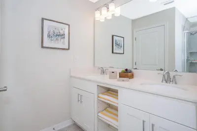 a white bathroom with two sinks and a mirror at 3111-102RD CONDO 2 BEDS/2 BATHS (SANITIZED) in Kissimmee