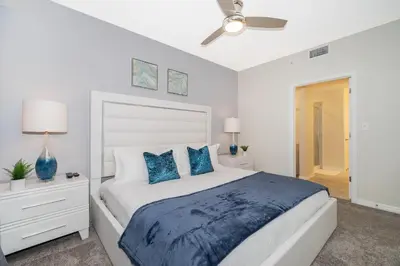 a bedroom with a large bed with blue pillows at 3111-102RD CONDO 2 BEDS/2 BATHS (SANITIZED) in Kissimmee