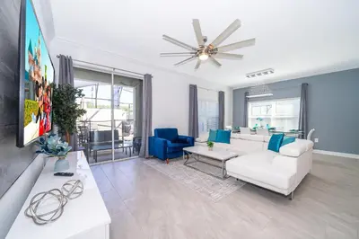 a living room with a white couch and blue chairs at 4415RH TOWNHOUSE 5 BEDROOMS & 4 BATHROOMS + POOL in Kissimmee