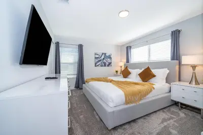 a bedroom with a bed and a flat screen tv at 4415RH TOWNHOUSE 5 BEDROOMS & 4 BATHROOMS + POOL in Kissimmee